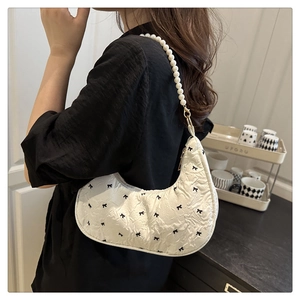 Détail du sac demi-lune blanc à motifs nœuds et bandoulière en perles chic