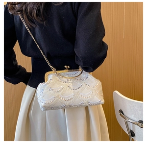 Detail of sequin lace evening bag with gold metal frame and elegant chain strap