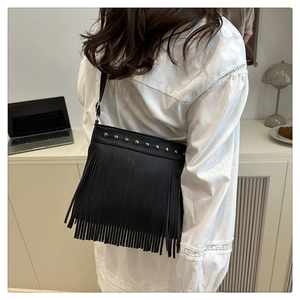 Détail du sac cabas en cuir noir avec clous métalliques et longues franges bohèmes