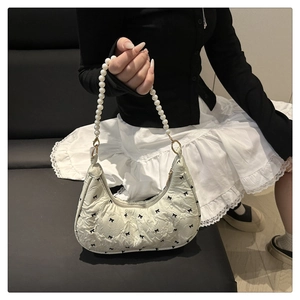 Détail du sac croissant blanc avec broderie nœud et bandoulière en perles