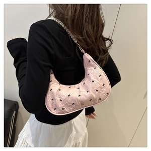 Détail du sac croissant rose avec motifs nœuds et une bandoulière en perles nacrées