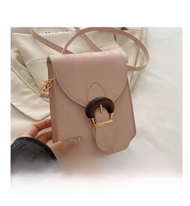Détail du mini sac bandoulière rose avec boucle fer à cheval en bois et métal doré