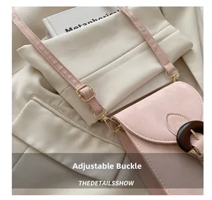 Détail du sac à bandoulière rose avec boucle dorée ajustable et fermoir marron