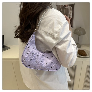 Détail du sac matelassé lilas avec nœuds noirs et bandoulière en perles chics