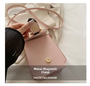 Vue détaillée du sac à bandoulière en cuir rose montrant le fermoir magnétique en métal