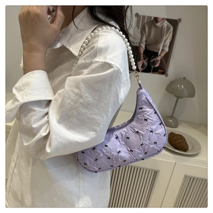 Détail du sac croissant lavande avec bandoulière perles et broderie nœud noir