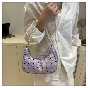 Détail du sac croissant violet clair avec motifs nœuds noirs et anse en perles