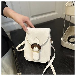 Gros plan détaillé d'un sac bandoulière vertical chic pour téléphone blanc crème avec boucle en bois.