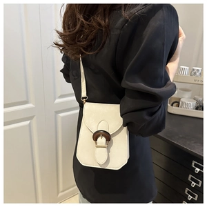 Détail du sac bandoulière en cuir PU crème avec boucle en bois vintage et finitions dorées