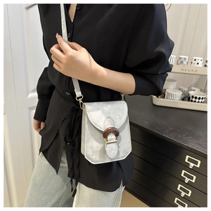 Détail du sac à bandoulière en cuir gris argenté avec boucle ronde en bois foncé