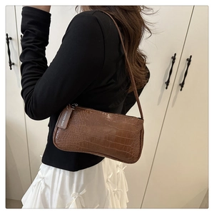 Detail showing brown crocodile pattern synthetic leather texture and fashion tag on side
