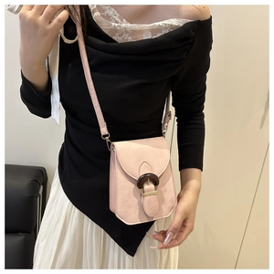 Détail du sac bandoulière rose clair avec boucle ronde style bois et bandoulière réglable