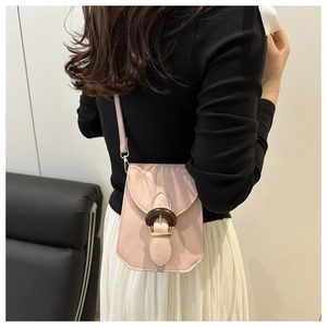 Gros plan détaillé d'un sac bandoulière vertical rose tendance avec boucle en bois.