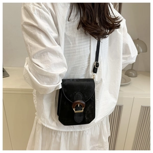 Détail de la grande boucle ovale en bois et des ferrures dorées sur le mini sac bandoulière