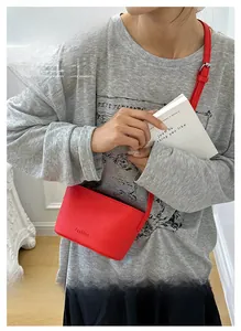 Détail du sac bandoulière rouge avec texture litchi et embossage de mode élégant