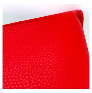 Vue macro de la texture en cuir rouge à motif litchi sur un sac bandoulière chic