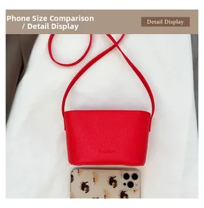 Détail d'un mini sac rouge en cuir grainé avec un téléphone pour comparer les dimensions