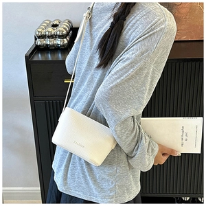 Détail du sac bandoulière blanc en cuir litchi avec texte Fashion minimaliste