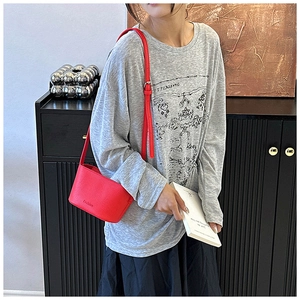 Gros plan d'un sac à bandoulière rouge texture litchi avec détail Fashion embossé
