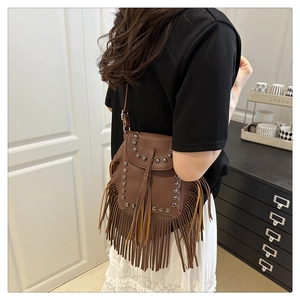 Detail der braunen Boho-Umhängetasche mit Vintage-Nieten und langen Lederfransen