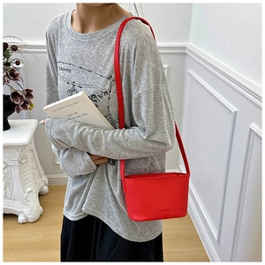 Détail du sac bandoulière rouge en cuir grainé avec logo Fashion gaufré