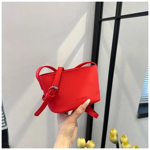 Détail de la mini sacoche rouge en cuir litchi avec logo Fashion embossé