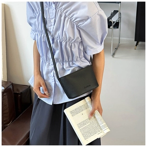 Détail d'un sac bandoulière noir en cuir grainé avec embossage de design Fashion