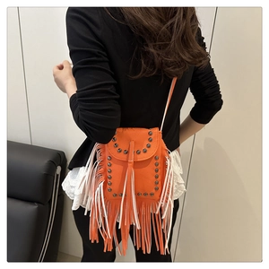 Detalle de mini bolso bandolera naranja brillante con remaches retro y flecos largos