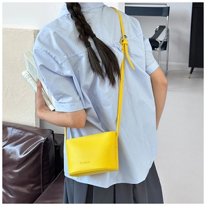 Détail du sac bandoulière jaune motif litchi avec logo Fashion et bandoulière réglable