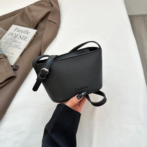 Sac bandoulière tendance en cuir grainé noir avec design incurvé et logo embossé
