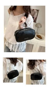 Détail du sac bandoulière noir brillant avec chaîne argentée et lettrage mode chic