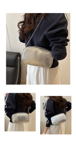 Détail d'un sac bandoulière argenté métallisé avec bandoulière chaîne et logo mode