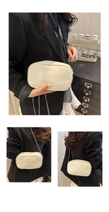 Détail d'un sac à bandoulière en cuir blanc crème avec chaîne et lettrage de mode