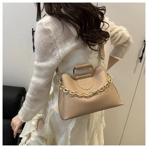 Detail of beige leather handbag with thick plastic chain strap and fashion lettering