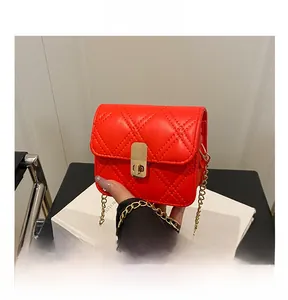 Close-up of red quilted PU leather handbag with golden twist lock and chain strap