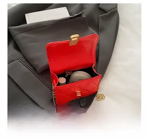 Detail view of the red quilted crossbody bag interior with lipstick and compact powder