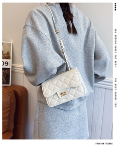 Détail du sac à bandoulière matelassé blanc avec fermoir doré et chaîne à billes réglable