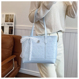 Détail du sac fourre-tout en cuir PU bleu clair avec nœud en dentelle et motifs en relief