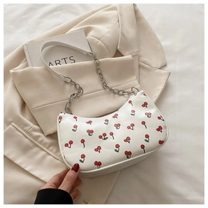 Detail of white cherry print bag with silver chain strap on lifestyle aesthetic background