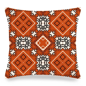Macro detail of the rust orange and beige geometric tribal pattern on linen pillowcase