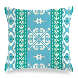 Detail of teal and white geometric ethnic pattern on linen texture throw pillow cover