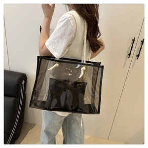 Detail of transparent PVC tote with black leather trim and white rope handles