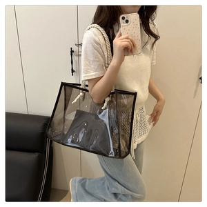 Modern transparent PVC tote bag with rope handles and inner pouch worn by a model