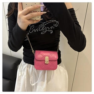Detail of fuchsia quilted mini bag with gold chain strap and twist-lock closure