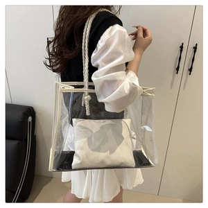 Close-up of clear PVC tote bag with white rope handles and a linen inner pouch