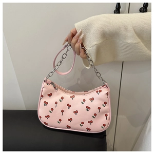 Detail of pink shoulder bag with cherry print and silver metal chain strap