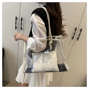 Close-up of a large transparent PVC tote bag with cotton rope handles and inner pouch