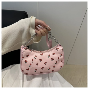Detailed view of pink cherry print handbag with silver chain strap and top zipper closure