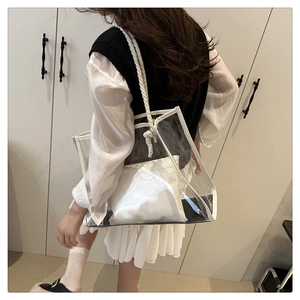Detail of transparent PVC tote bag with white rope straps and inner pouch on model