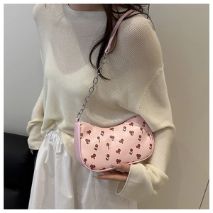 Close-up of pink cherry print shoulder bag with metal chain strap and PU leather detail